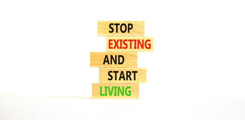 Stop existing start living symbol. Concept words Stop existing and start living on wooden blocks....