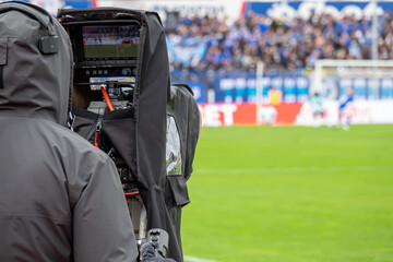 TV camera at the stadium, broadcasting during a football, soccer match