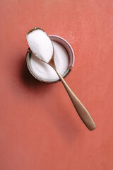 spoon with sugar on color background orange gold spoon