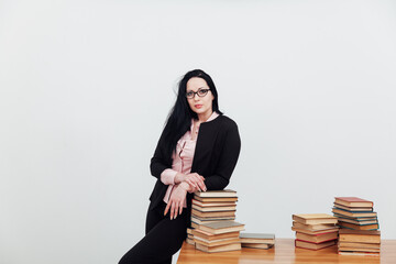 a female librarian teacher stands near a stack of books