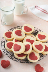 Valentines day cookies. Shortbread cookies inside a sweet red heart on pink plate on pink background. Mothers day. Womans day. Sweet holidays baking. Top view.