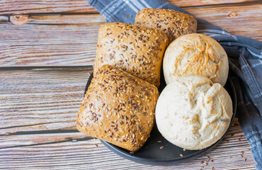 
buns with seeds on a daily table, on a rustic wooden background.