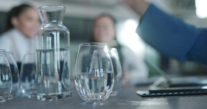 Business people, hands and pouring glass of water for meeting, discussion or planning on a table. Hand of thirsty employee filling cup half full on office desk for hydration in preparation for speech