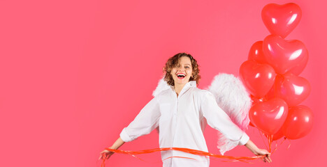 Smiling woman with red heart shaped balloons. Cute angel girl. Cute cupid in angelic wings.