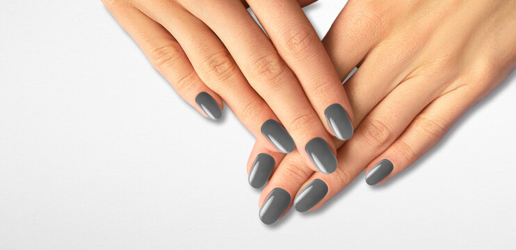 Beautiful Groomed Woman's Hands With Gray Nails On The Light Gray Background.