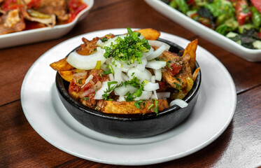 Beef stew with potatoes, carrots and herbs on black background with copy