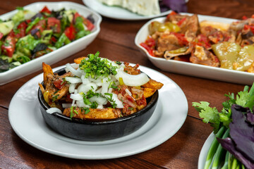 Beef stew with potatoes, carrots and herbs on black background with copy