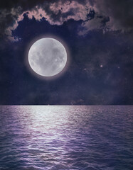 Naklejka na ściany i meble Beautiful Romantic Full Moon Ocean Reflection - dark blue sky with pink tinged clouds and a low full moon over rippling water ideal for astrology or spiritual pagan theme background 