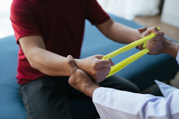 Physiotherapist Giving Man A Training With Exercise Band. resistance training.
