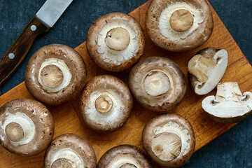 Fresh uncooked Royal Champignons on a wooden cutting board, top view, close up - 566668630