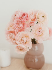 Bouquet pale pink ranunculus flowers in vase on light background