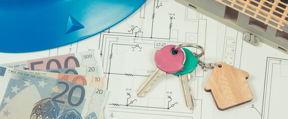 Home keys, currencies euro, electrical construction diagrams and small house under contruction....