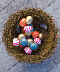 Vibrant patterned Easter eggs in a nest on a wooden table looking down 3d render