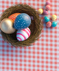 Conceptual Easter eggs of various sizes on a red and white blanket in a nest 3d render