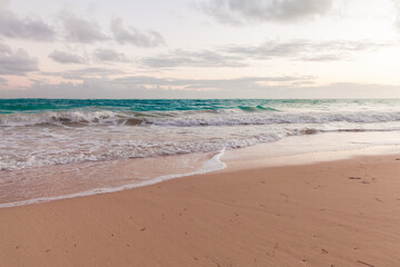 Fototapeta na wymiar Empty sandy beach and shore waves in the morning