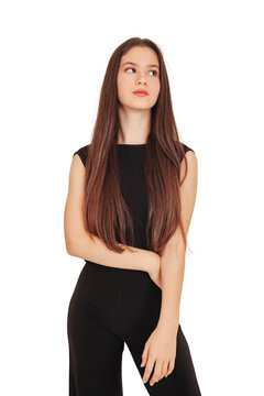 Portrait elegant teenager girl model with long hair posing in black clothes at empty white isolated background, looking away. Teen girl shooting in studio. Modelling concept. Copy text space for ad