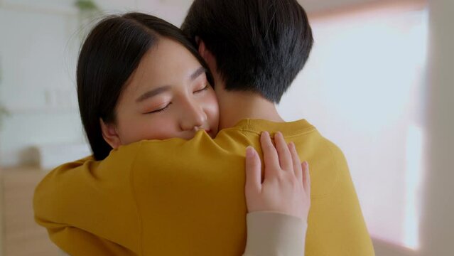 Asian young husband hug offended sad wife ask forgiveness apologize after quarrel conflict fight. Man try to make peace with stubborn sulky women admit his fault. Forgive me please.