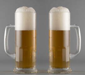 Light beer with foam in a tall glass on a gray background, light alcohol