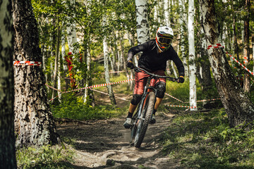 rider of mountain bike downhill forest trail
