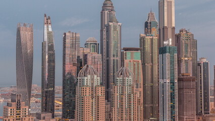 Skyscrapers of Dubai Marina near intersection on Sheikh Zayed Road with highest residential buildings night to day