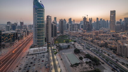 Naklejka na ściany i meble Dubai's business bay towers aerial day to night . Rooftop view of some skyscrapers