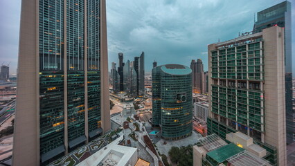 Dubai international financial center skyscrapers aerial night to day .