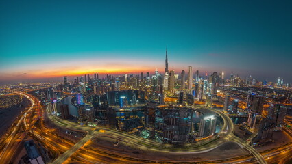 Panoramic skyline of Dubai with business bay and downtown district day to night .