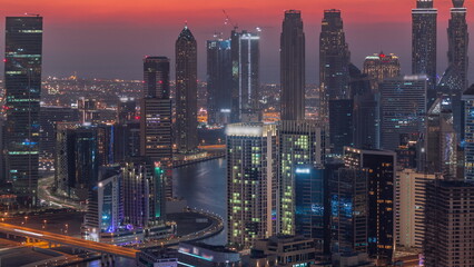 Skyline with modern architecture of Dubai business bay towers day to night . Aerial view