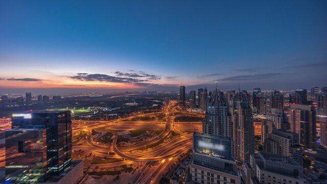 Huge highway crossroad junction between JLT district and Dubai Marina night to day . © neiezhmakov