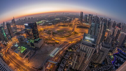 Fototapeta na wymiar Dubai marina and JLT skyscrapers along Sheikh Zayed Road aerial night to day .