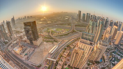 Sunrise over Dubai marina and JLT skyscrapers along Sheikh Zayed Road aerial .