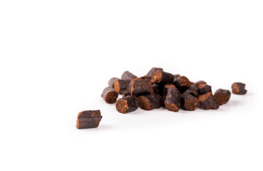 Isolated dog treat for obedience training with defocused pile of treats. Natural baked small chicken pieces. Mini sizes ideal for dog training, tricks and reward. Selective focus. White background.