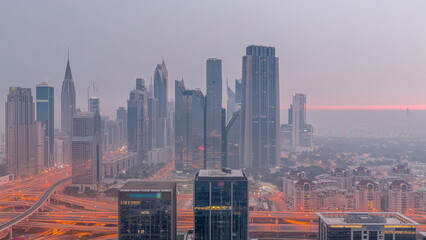 Panorama of Dubai Financial Center district with tall skyscrapers with illumination night to day .