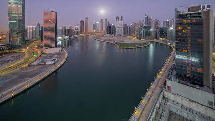 Fototapeta na wymiar Cityscape of skyscrapers in Dubai Business Bay with water canal aerial night to day