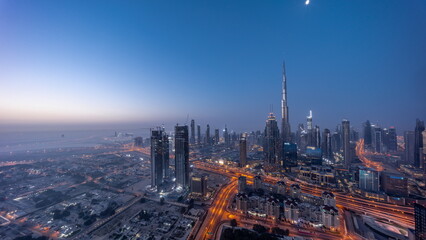 Aerial view of tallest towers in Dubai Downtown skyline and highway night to day .