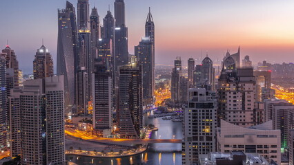 View of various skyscrapers in tallest recidential block in Dubai Marina aerial night to day