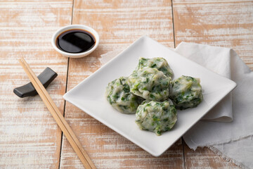 Chinese Chive Dumplings,Steamed Dumpling stuffed with Garlic Chives on white plate with sauce