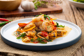 Stir-Fried Shrimp ,green Mussels and squid with thai holy Basil on white plate