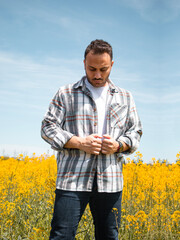 Man in Canola Field. He is wearing a shirt.