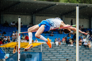 male jumper competition high jump in rain