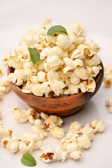 closeup the bunch white yellow popcorn with green mint leaves isolated on white background.