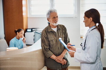 Obraz premium Senior man communicating with his doctor at medical clinic.