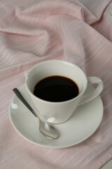 Cup of aromatic coffee on white wooden table