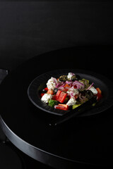 Close up of  Greek salad on black table food close up