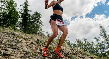 female runner running down mountain trail
