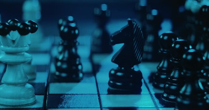 Chess game. Close-up view hand makes strategic move with figure on board. Smart thought of grandmaster, victory. Focusing on king. Checkmate. Sports concentration. Attack and Logical Step Forward.
