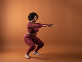 body positive curvy black girl wearing sportswear in studio doing yoga and exercising - obrazy, fototapety, plakaty