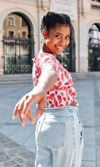 Young woman smiling while stretches out her hand back to invite someone.