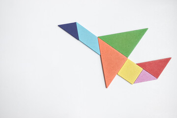 color wood tangram puzzle in airplane shape on white background