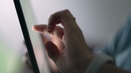 Closeup hand touching tablet screen. Person holding device browsing internet